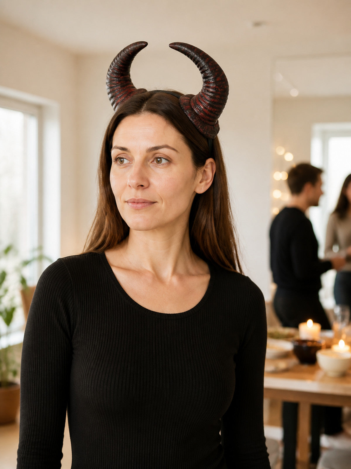 Red and black textured horn headband shown on a model in a three-quarter portrait inside a room