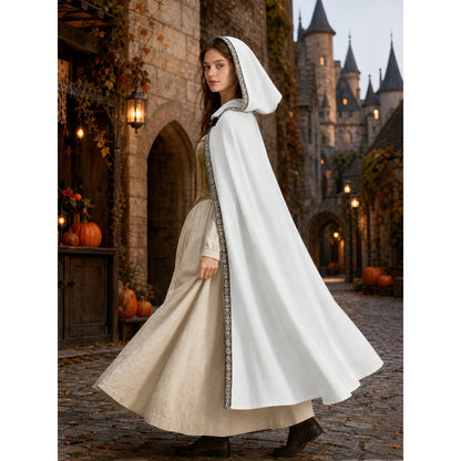 White hooded cape with patterned trim, shown in profile on a model walking through a medieval-style courtyard