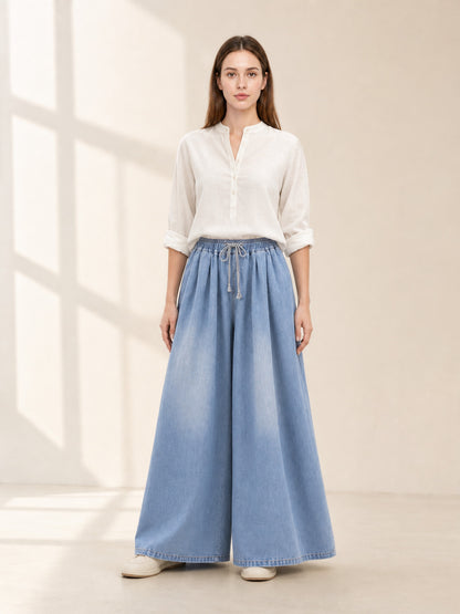 The model features a relaxed style with very wide, full-length legs that create
