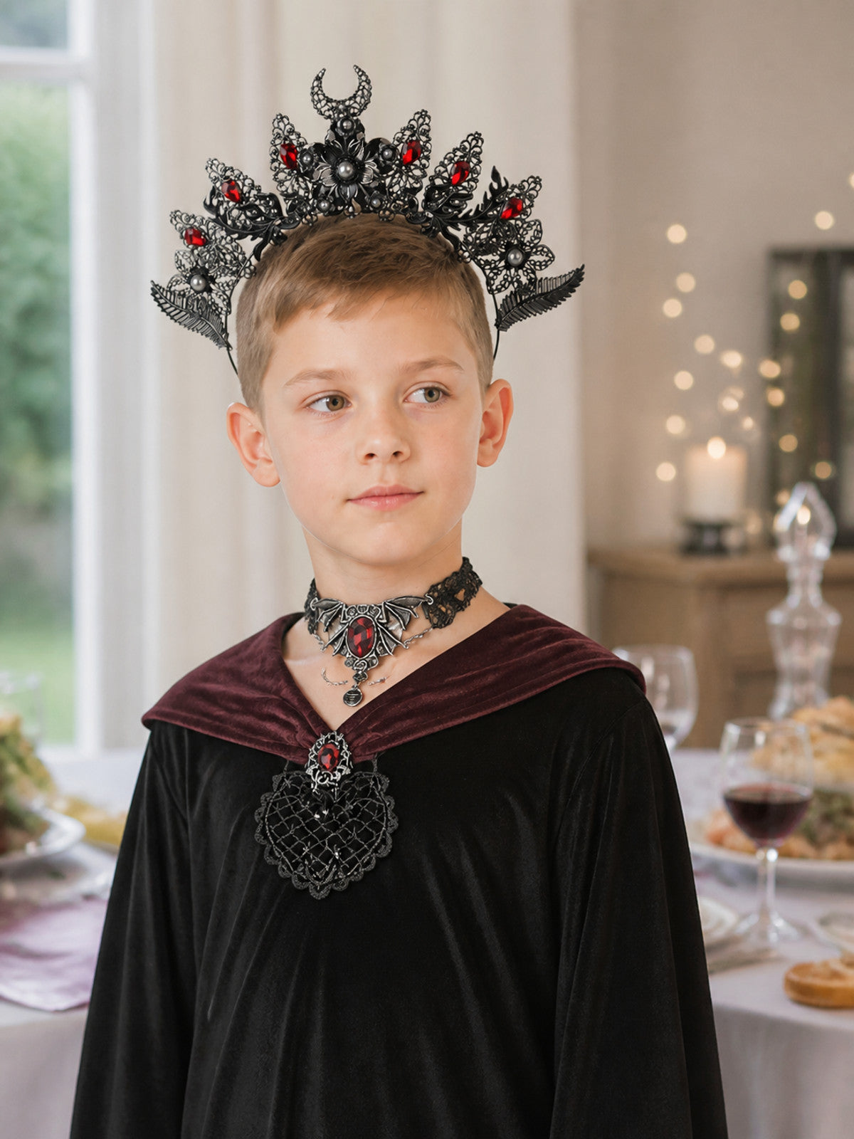 Black and silver-look horned headpiece with red stones and ornate filigree, shown on a child wearing a dark costume and matching choker