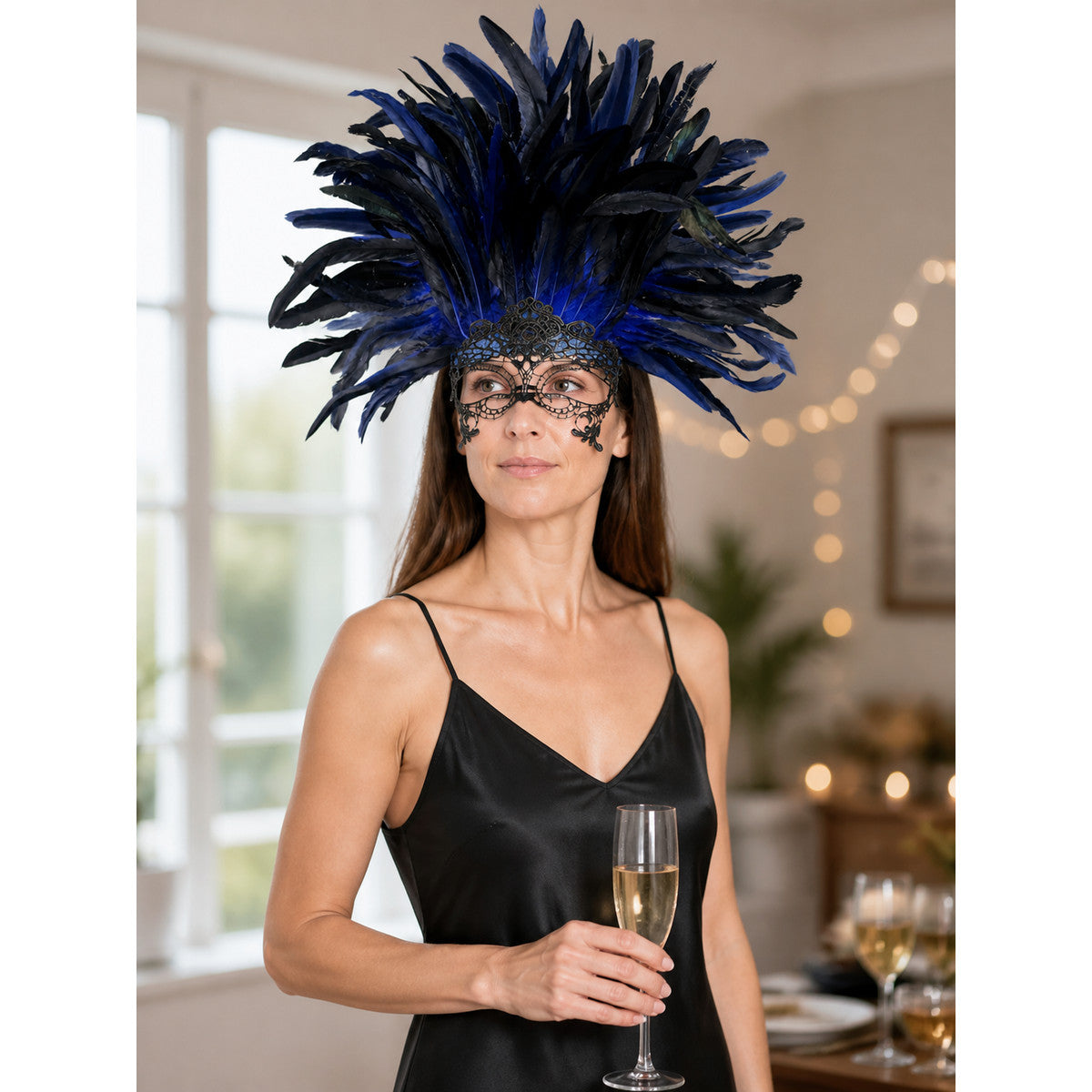 Blue and black feather headpiece with a black filigree eye mask, shown on a model wearing a black satin slip dress