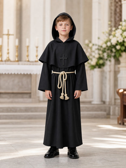 Full-body child model wearing a black hooded robe with a cross detail and cord belt in an indoor church setting