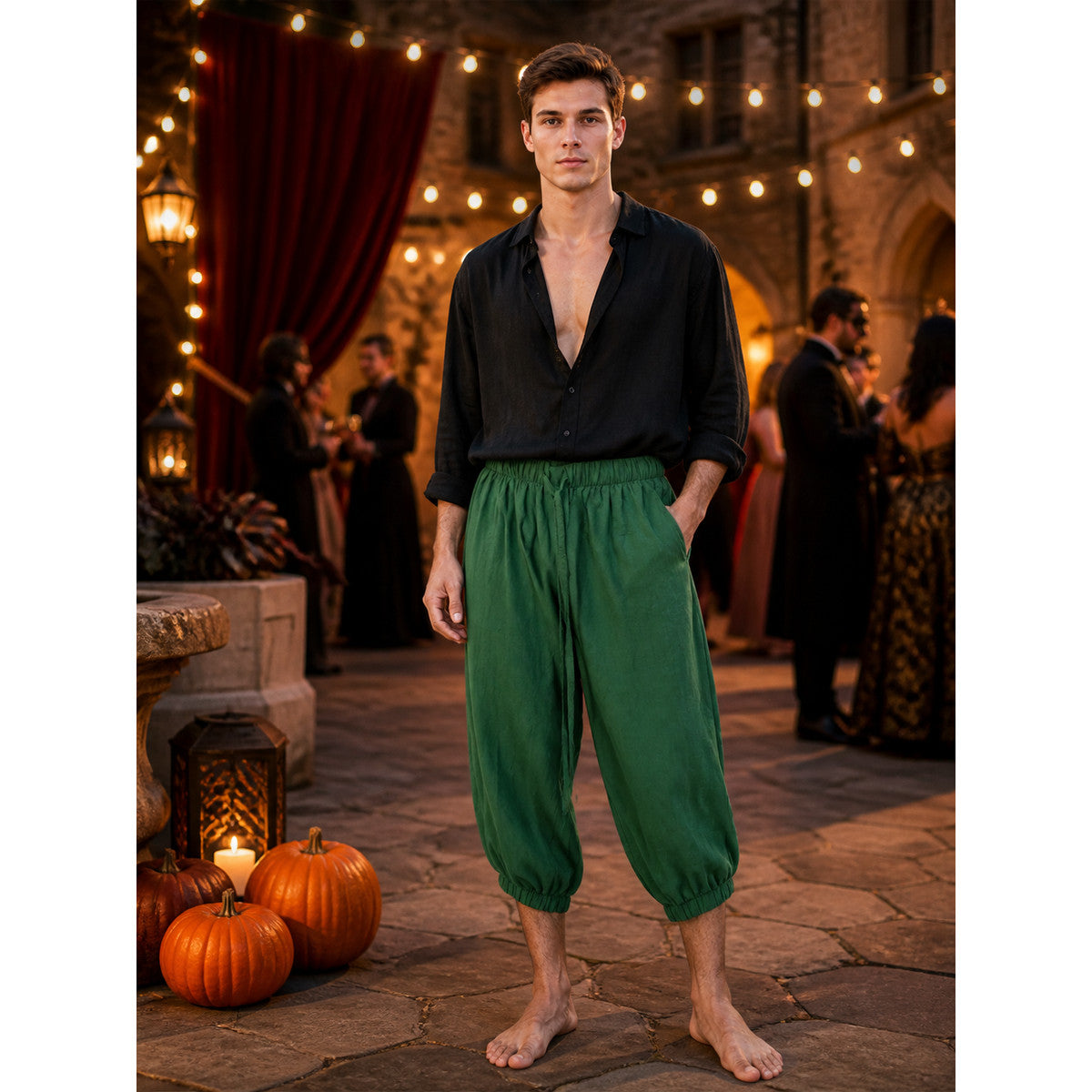 Dark green cuffed pants with an elastic waist and drawstring on a model in a styled evening scene