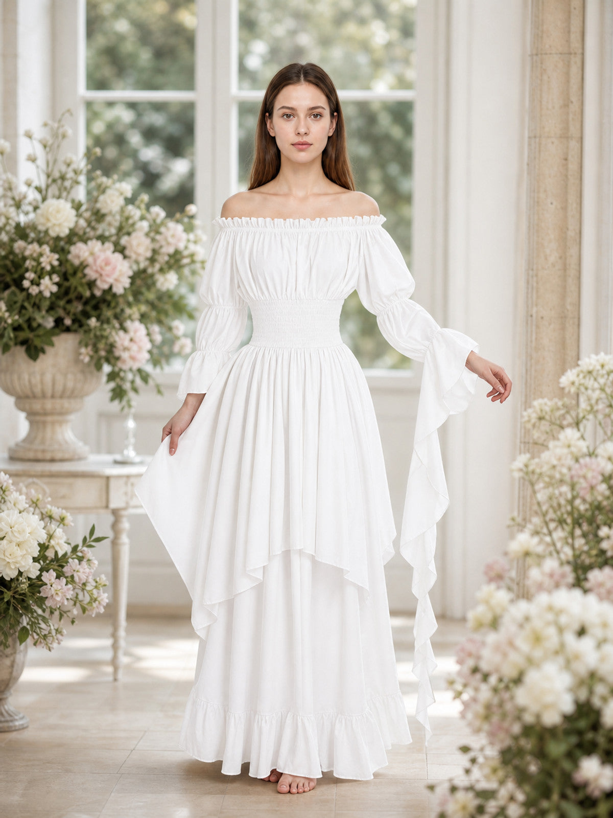 White gathered off-shoulder dress shown full-length on a model in a flower-filled interior, with flared sleeves, layered skirt, and ruffled hem