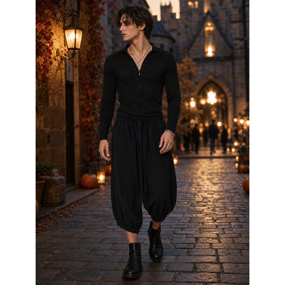 Black cropped pants with a relaxed silhouette and elastic cuffs, shown on a model walking through a lit street