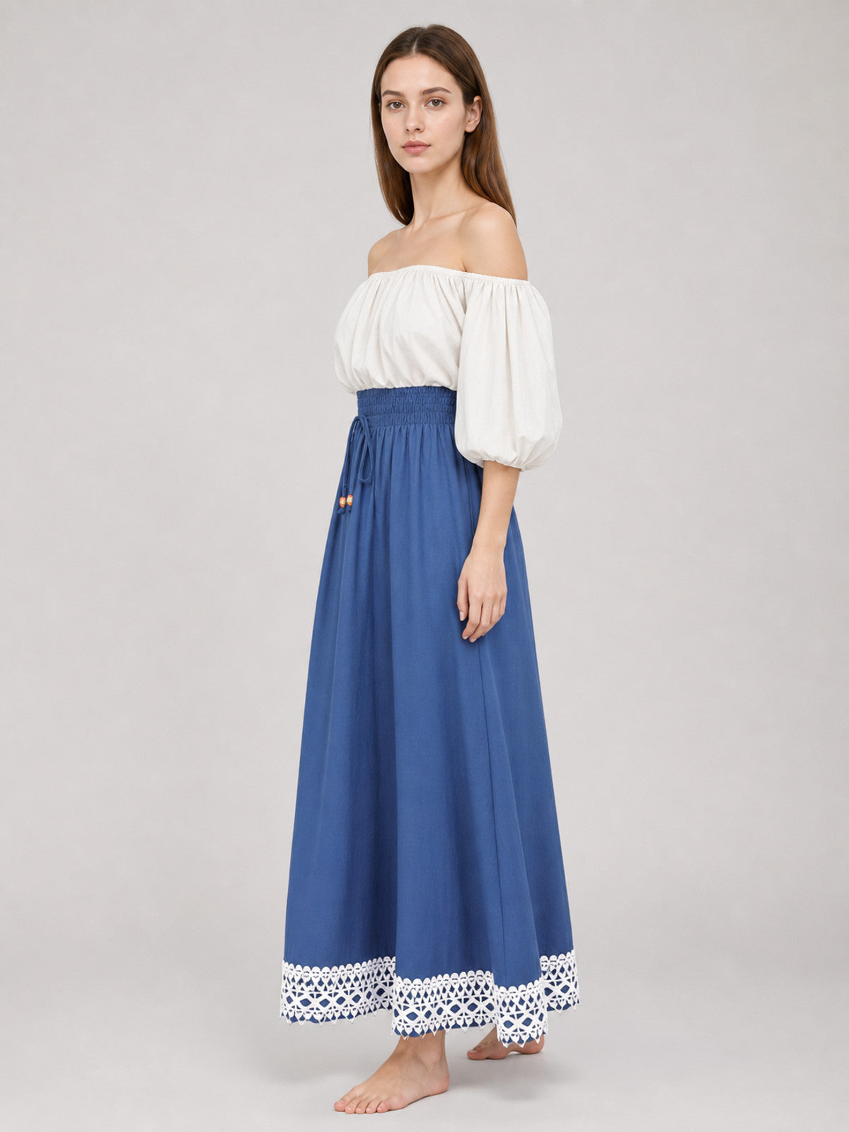 Side view of a blue ankle-length dress with a gathered elastic waist, white off-shoulder puff sleeves, and lace-trimmed hem