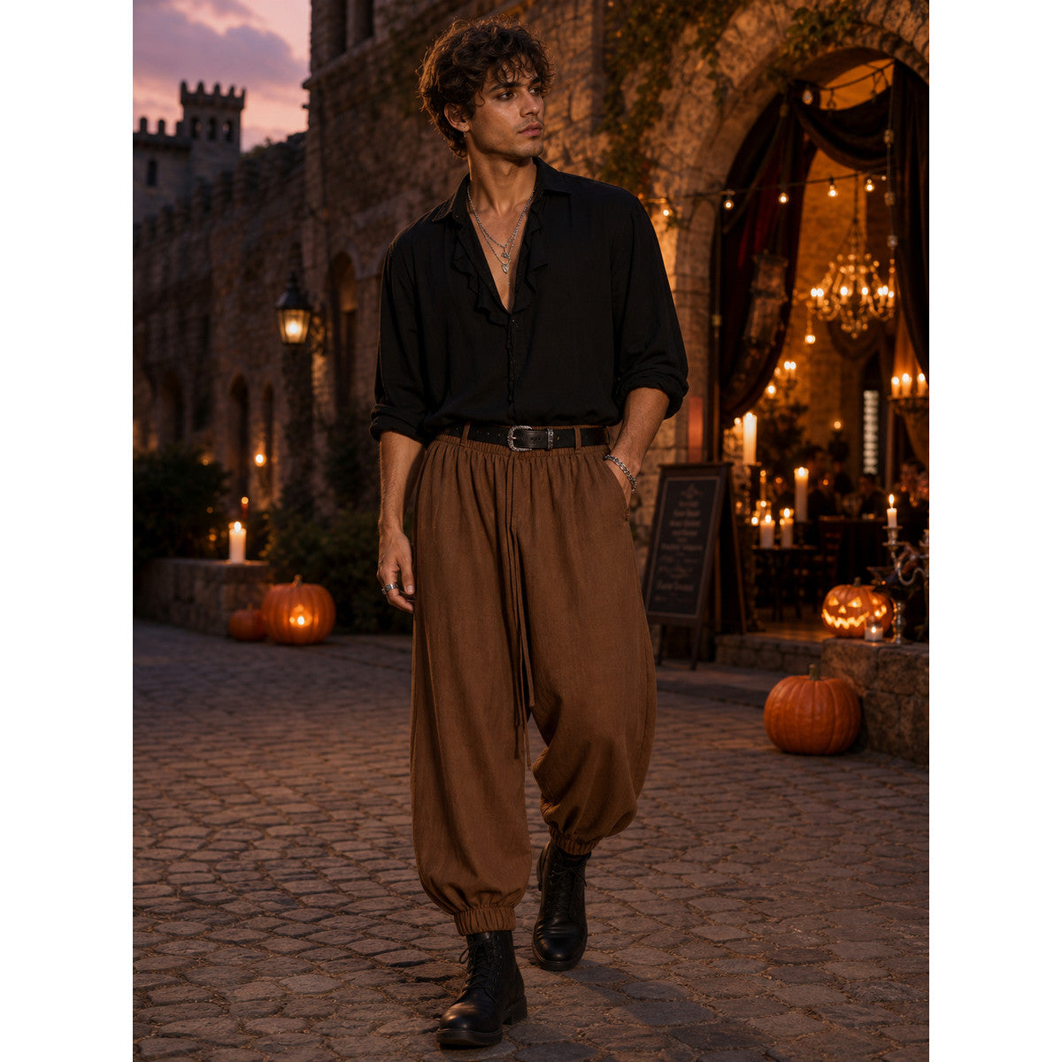 Brown cropped jogger pants with a loose fit and elastic ankle cuffs, styled on a model outdoors with a black shirt and boots