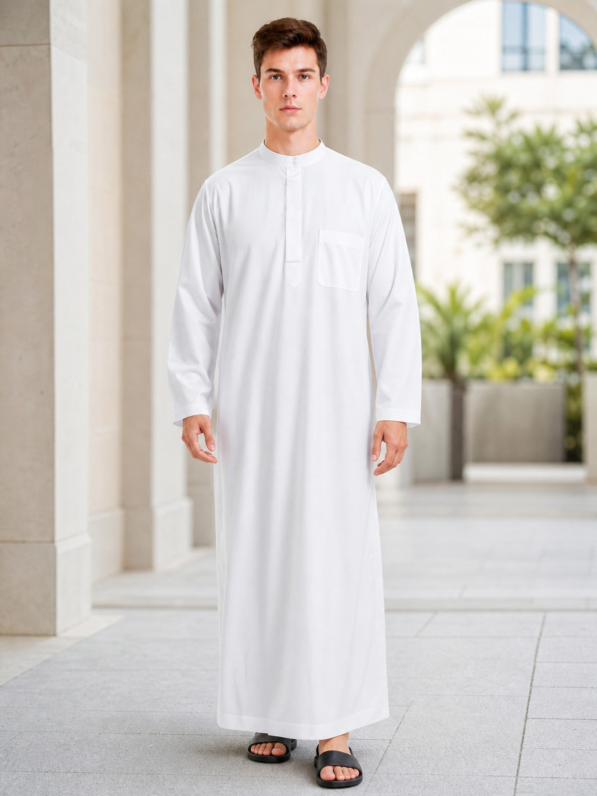 White long robe with smooth fabric, stand collar, chest pocket and long sleeves, shown full-body on a model in an outdoor setting