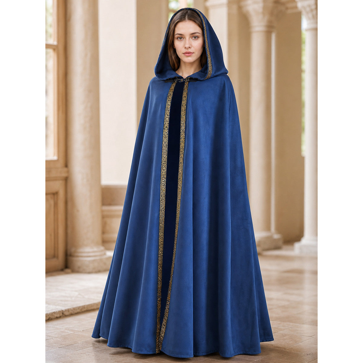 Blue hooded cloak with gold-patterned trim and a floor-length silhouette, shown on a model in a columned room