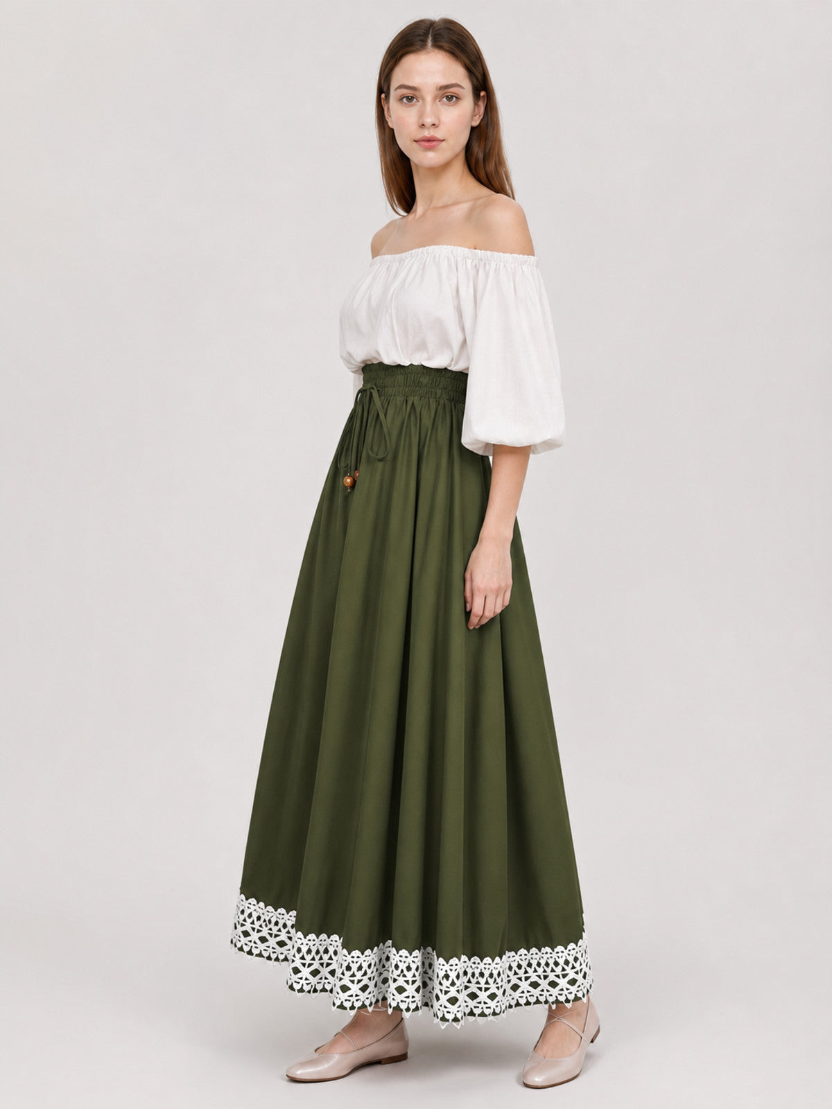 Full-body side view of an olive green maxi dress with a flowing skirt, white off-shoulder bodice, gathered waist, and lace-trimmed hem
