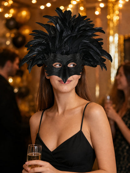 Black feathered bird mask worn by a woman in a black dress at a decorated evening event