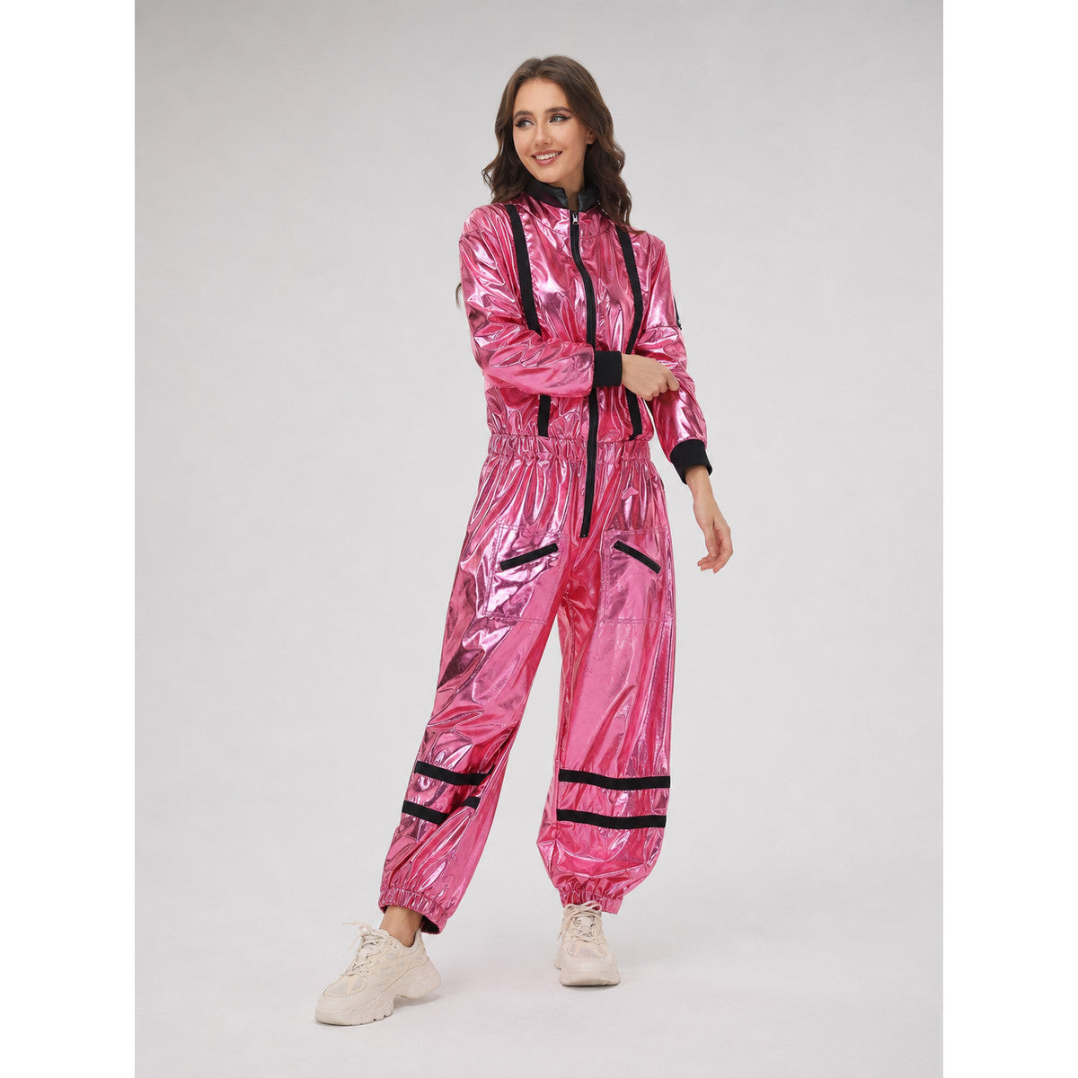 The pink NASA astronaut costume is designed as a one-piece jumpsuit with long sleeves, a stand-up collar, and a central zip closure. The model is pink with black decorative elements: a vertical stripe on the front, zippered side pockets, ho