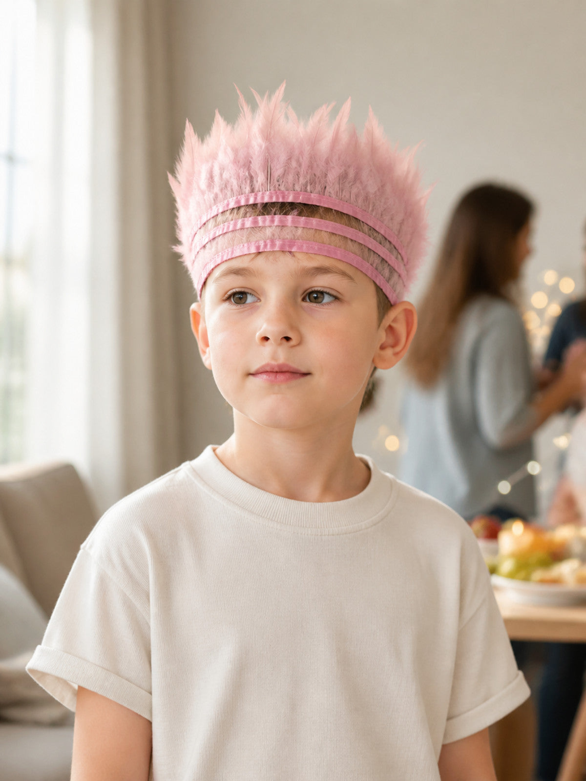 Pink feather headpiece with layered pink bands, shown on a child in a styled indoor scene