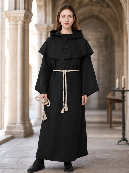 Black hooded monk robe on a full-body model in a church setting, showing a cross, wide sleeves, cream rope belt, and rope loop