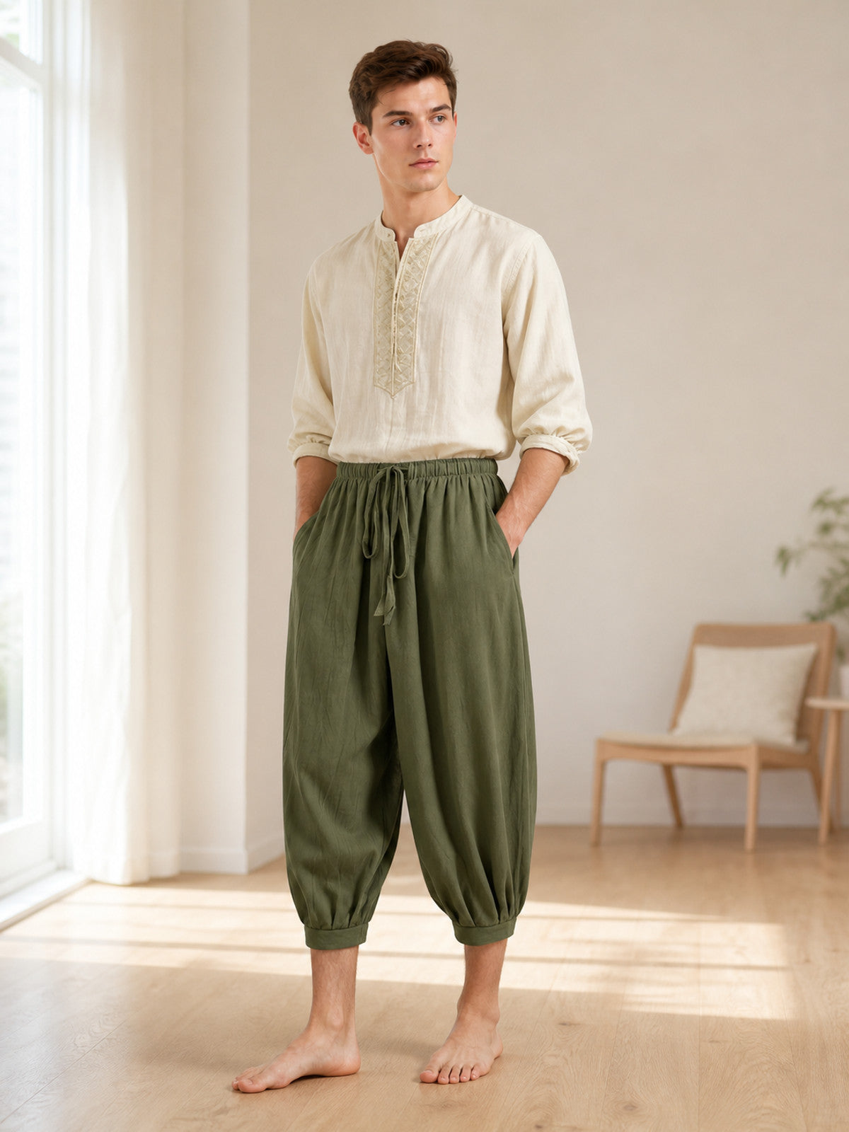 Olive green cropped harem pants with gathered cuffs and drawstring waist, shown on a male model indoors