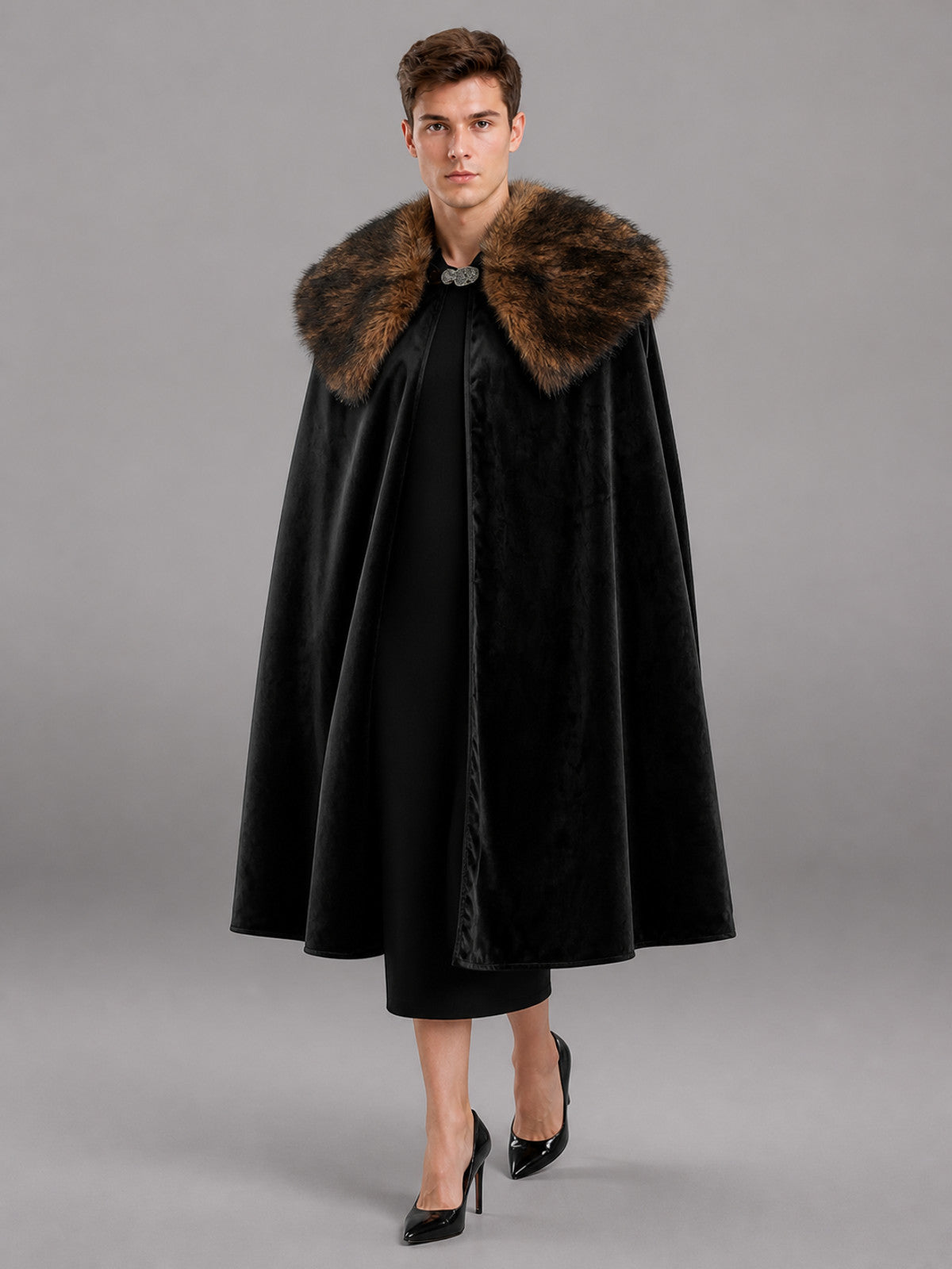 Black cape with a brown fur collar and front clasp, shown full-length on a male model in a gray studio