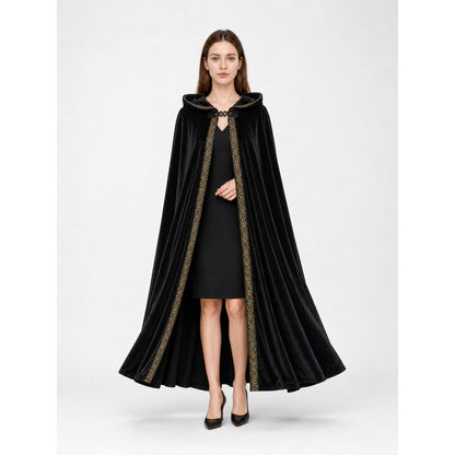 Front view of a black velvet-look hooded cloak on a model, showing a full draped shape and patterned front trim