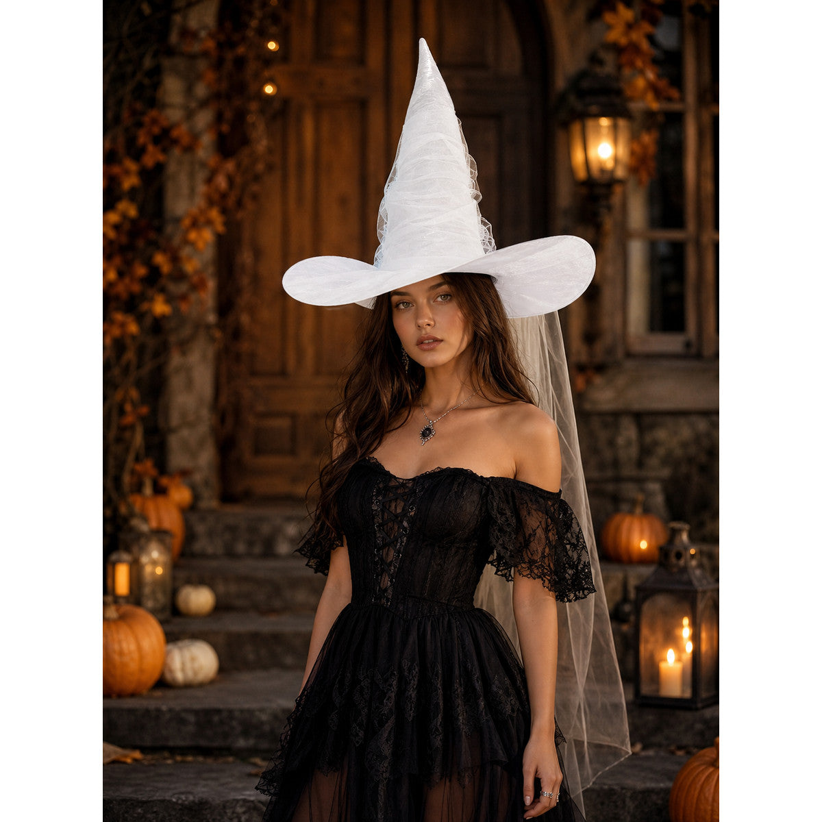 White tall pointed witch hat with a wide brim and attached sheer veil, shown on a model in a black lace dress outdoors