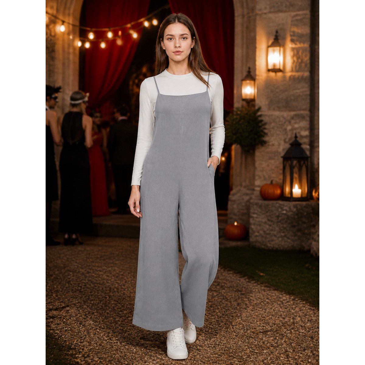 Gray wide-leg overalls with thin straps shown full-body on a model wearing a white long-sleeve top and white sneakers