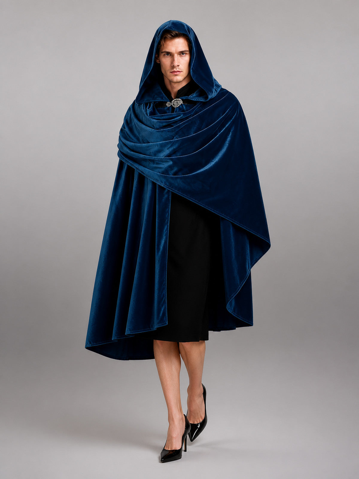 Dark blue hooded velvet-look cloak shown from the front on a model, with layered draping and a clasp at the neck