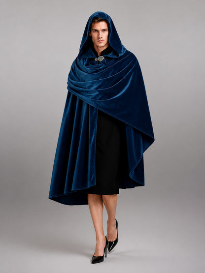 Dark blue hooded velvet-look cloak shown from the front on a model, with layered draping and a clasp at the neck