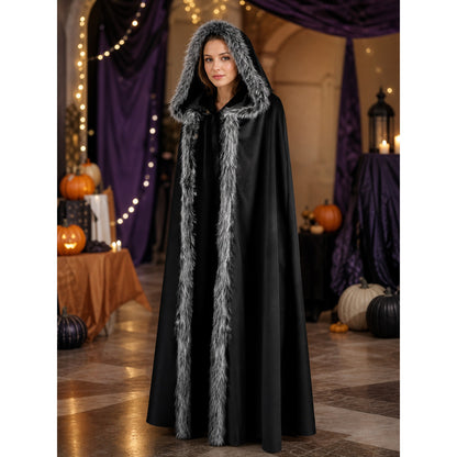 Black hooded cape with shaggy gray trim shown on a model in a decorated room with pumpkins and purple drapes