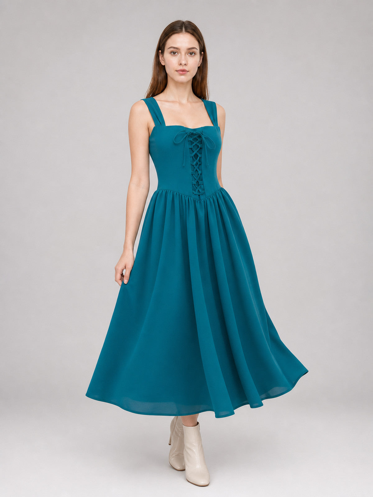 Teal sleeveless dress with a lace-up bodice and flowing full skirt shown on a model in a three-quarter pose