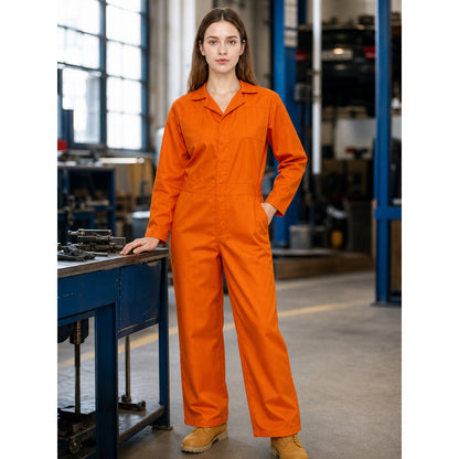 Woman wearing an orange jumpsuit in a workshop, shown beside a workbench with one hand in a pocket and tan work boots