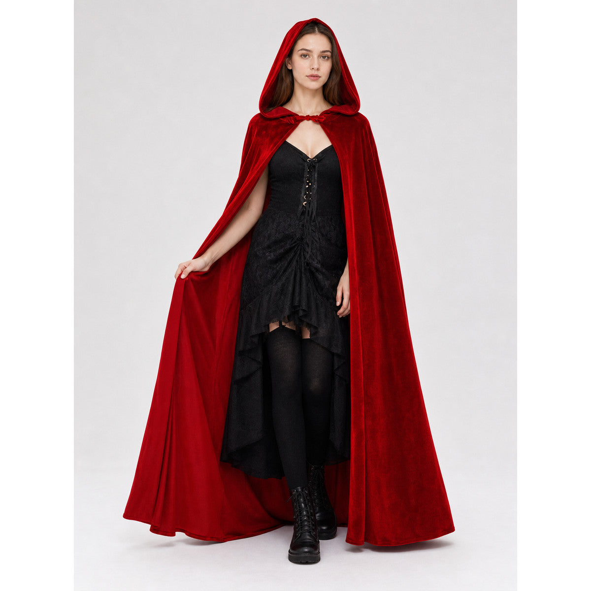 Red velvet hooded cloak shown full-body with one side held open, revealing a black corset dress and long cape panels