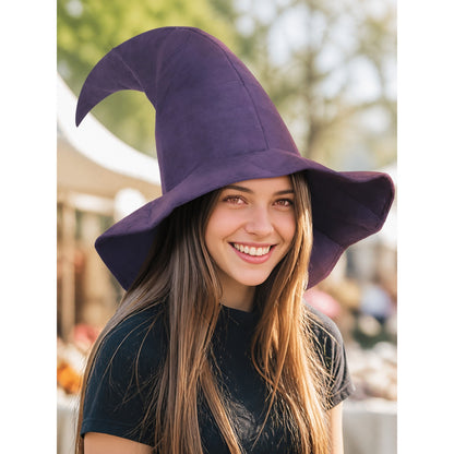 Purple fabric witch hat with a tall curved crown and wide brim, shown on a smiling woman in an outdoor setting