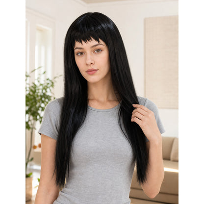 Black straight wig with blunt bangs shown on a model in a gray T-shirt in a furnished room