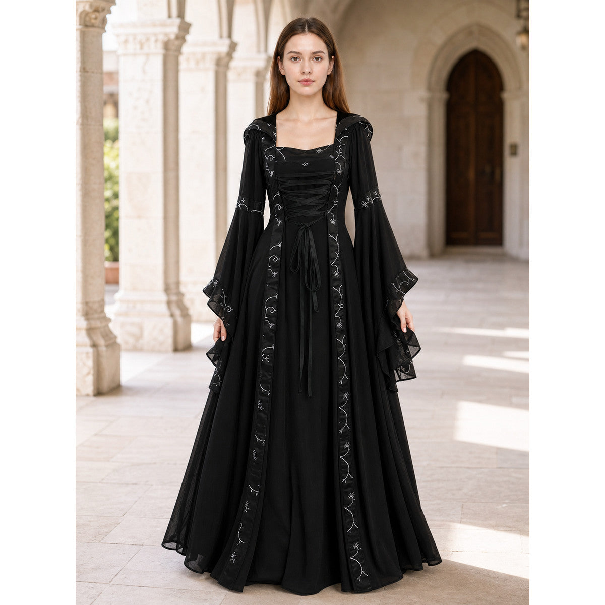 The dress is designed in a gothic style with elements of Victorian aesthetics. The model features a flared silhouette, a square neckline, and long sleeves with flared cuffs. The bodice is decorated with gathers that emphasize the garment’s 