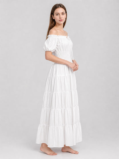 White off-shoulder maxi dress with short puff sleeves, smocked waist, and tiered skirt shown from a three-quarter side view