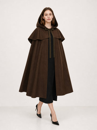 Brown hooded cape with shoulder overlay and front ties, shown full-length on a model over a black dress