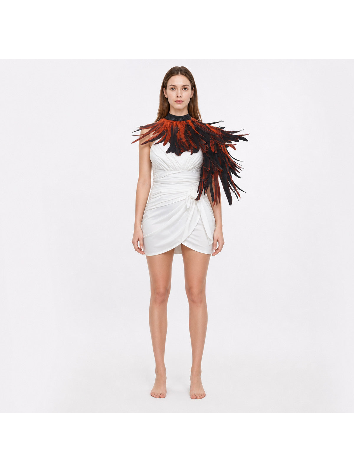 Orange and black feather shoulder cape on a model in a white ruched dress, shown full-body against a plain white background