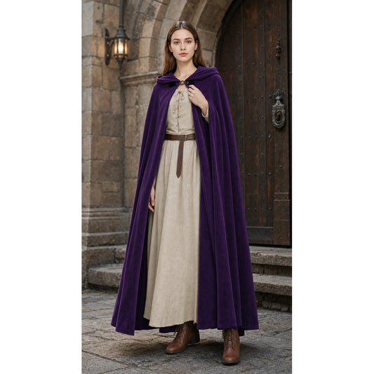 Purple velvet hooded cloak shown full-body on a model over a beige dress, with a front clasp and long flowing panels