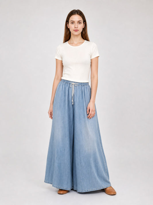 Light blue wide-leg denim pants with a drawstring waist, shown full-length on a model with a white T-shirt