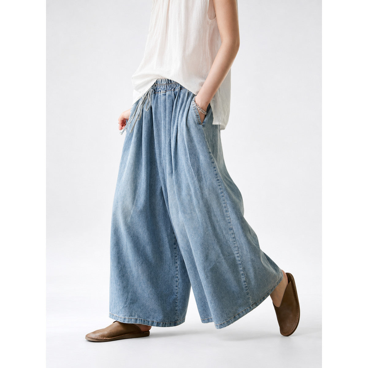 Casual culotte jeans in a light blue denim wash with a relaxed silhouette and cropped mid-calf length. The style features wide legs, classic denim stitching, and a noticeable faded texture. An elastic waistband and visible drawstring comple