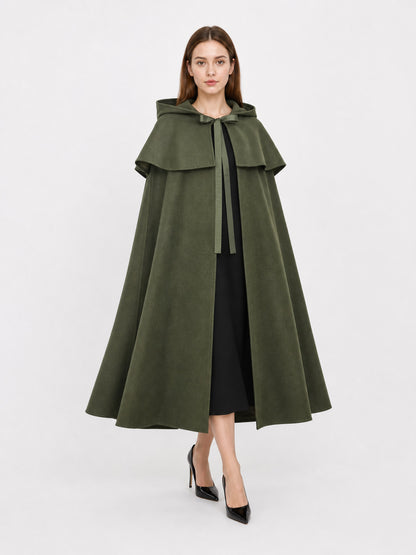 Olive green fabric cloak shown full-body on a model, with a hood, layered shoulder cape, front tie, and flared hem