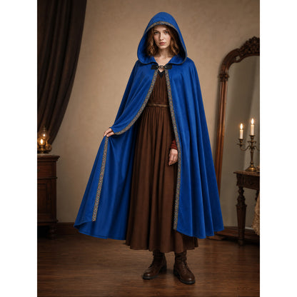 Blue hooded cloak with patterned trim, shown full-length on a model over a brown dress in a candlelit room