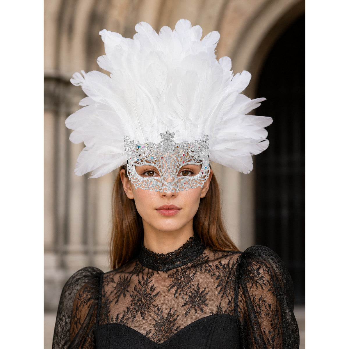 White feather masquerade mask with a silver-tone ornate frame, shown worn in a close-up portrait with a black lace top