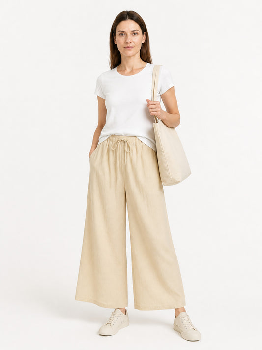 Light khaki wide-leg pants with a gathered drawstring waistband and side pockets, shown full-length on a model with a white T-shirt
