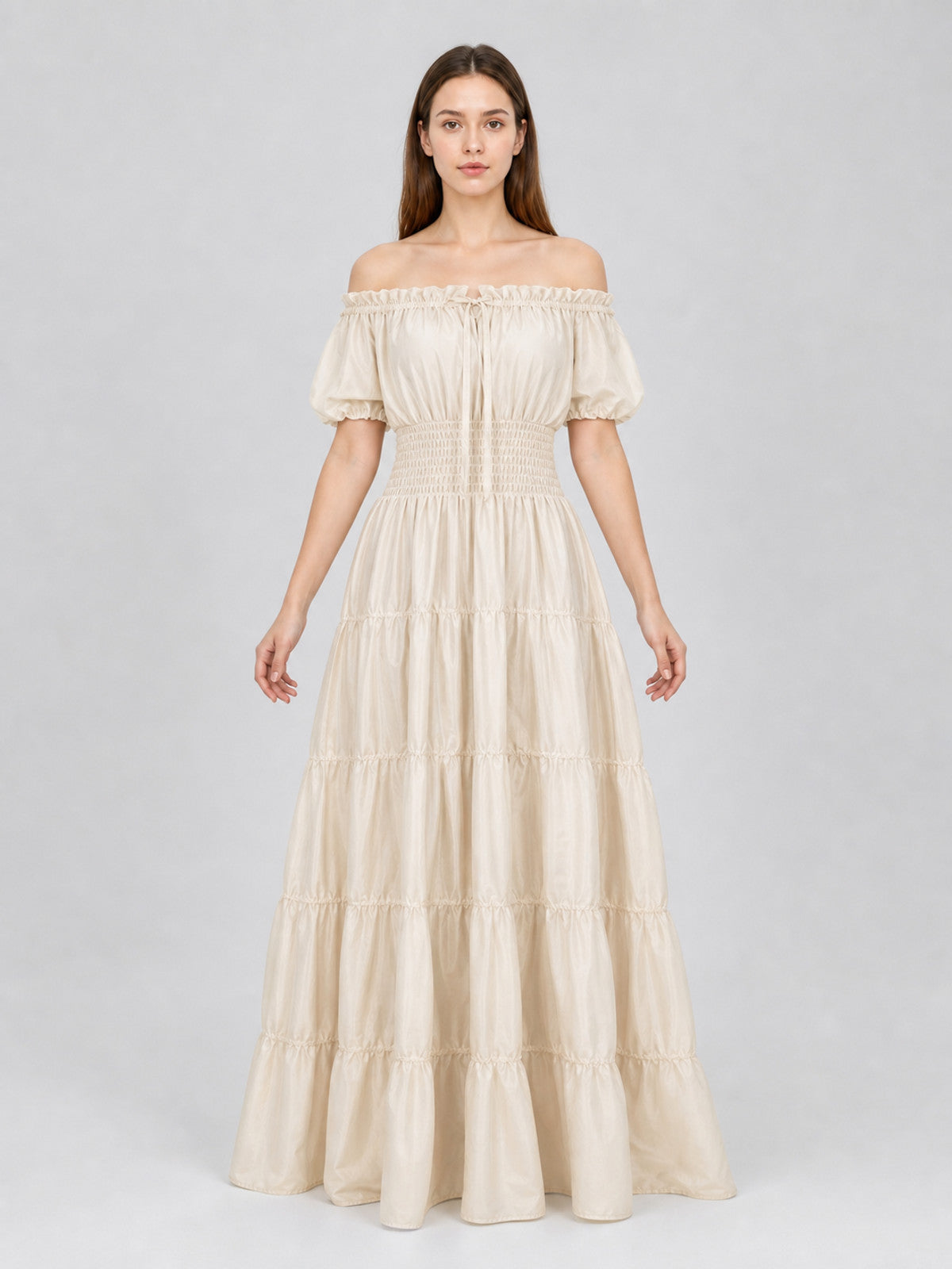 Cream off-shoulder dress with short puff sleeves, gathered waist, and tiered floor-length skirt shown full-body on a model