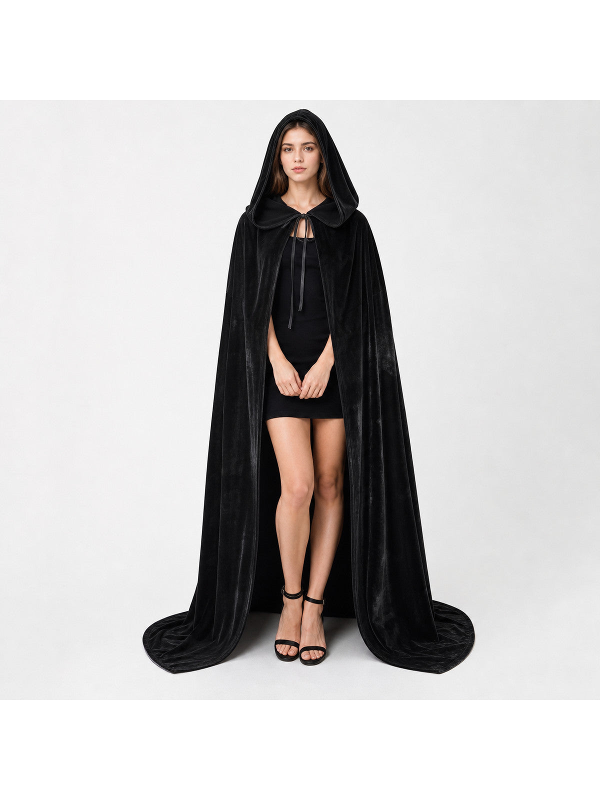 Full-body studio view of a black hooded cape with a front tie, open front, and long trailing hem on a model