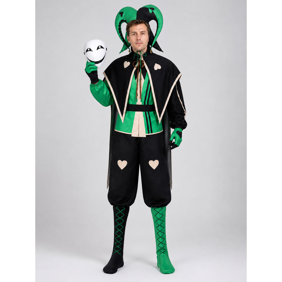 Model wearing the adult black and green jester clown costume: jester hat, white smiling mask, black cape, green jumpsuit and leg covers, front view