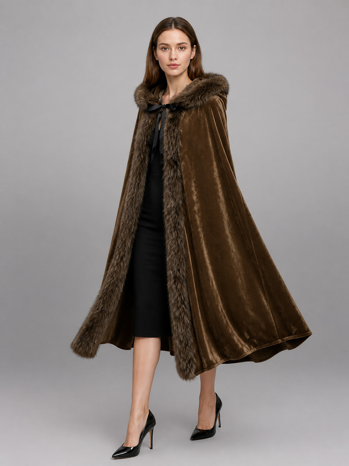 Brown velvet-look hooded cape with faux-fur trim, shown full-body on a model over a black dress