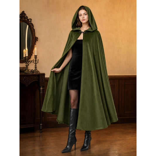 Green velvet-look hooded cloak shown full-body on a model in a dark styled room