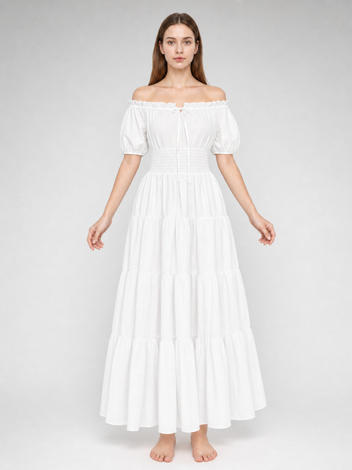 White lightweight-looking off-shoulder maxi dress on a full-body model, with short puff sleeves, a smocked waist, and tiered floor-length skirt