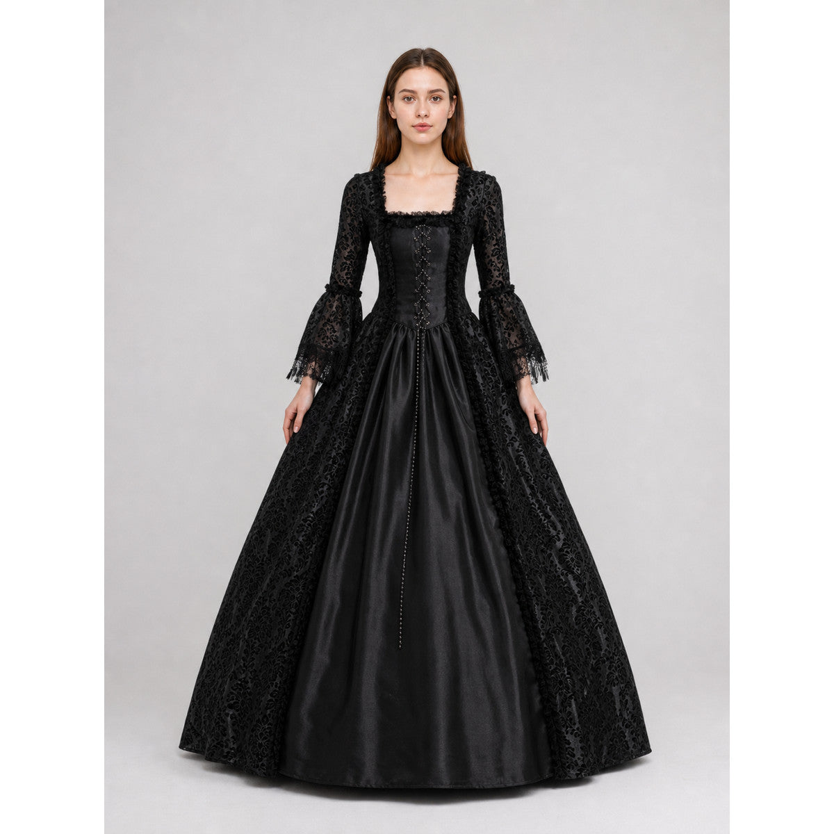 The black dress is designed in the aesthetic of a Victorian-era Gothic costume. The model features a floor-length silhouette, a fitted bodice with a square neckline, and decorative lacing or trim on the front. The long flared sleeves end in