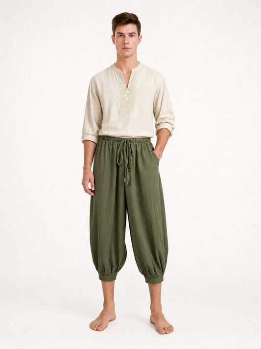 Olive green cropped harem pants with a drawstring waist and pockets, shown full-body on a male model